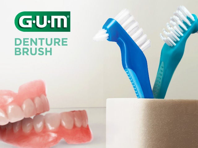 GUM DENTURE BRUSH with two Toothbrushes placed in a glass in the Bathroom, plus a denture