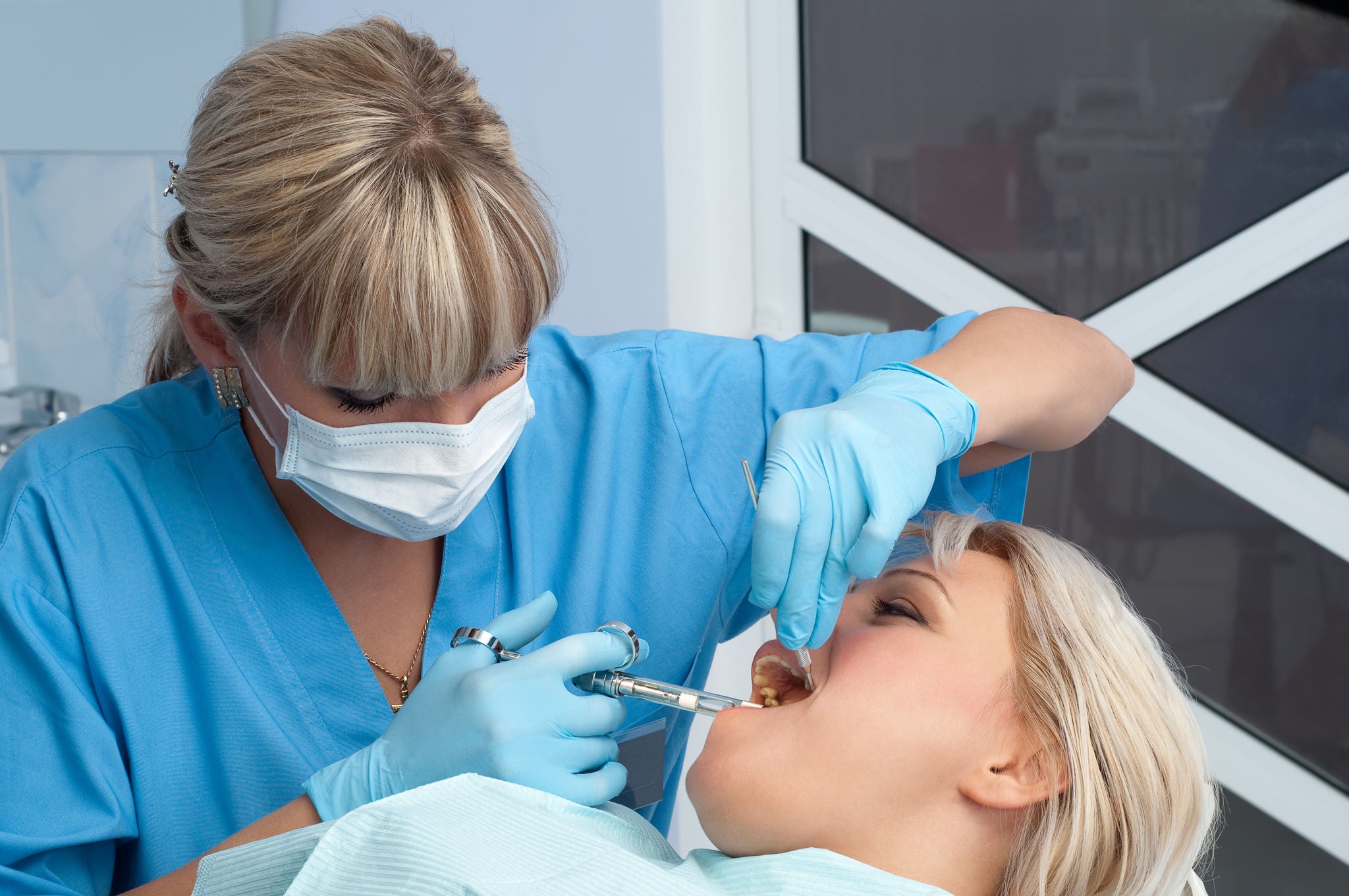 female dentist at work, anaesthesia injection before cavity stopping