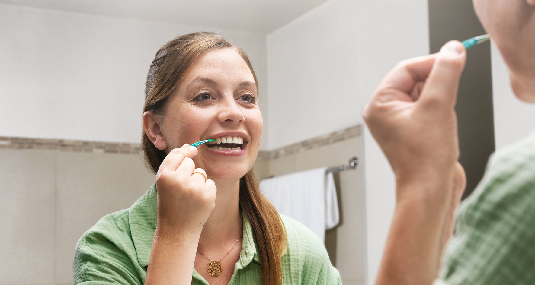 In-context-GUM-SOFT-PICKS-PRO-woman-cleaning-between-her-teeth-cropped