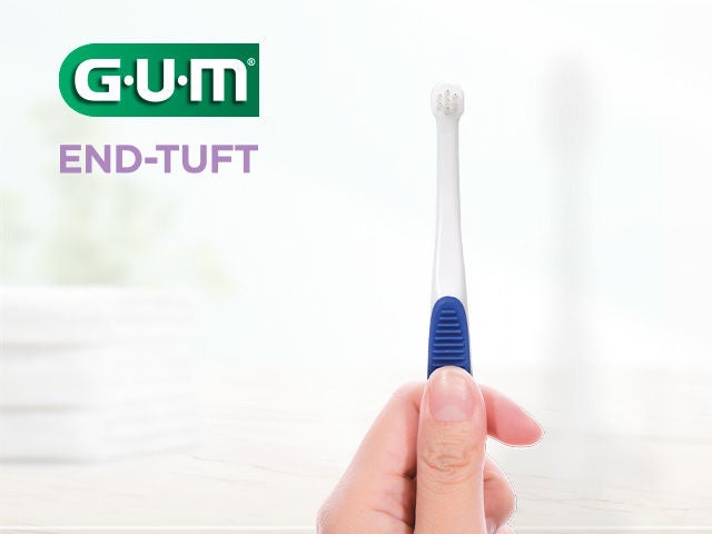 GUM END-TUFT toothbrush in hand