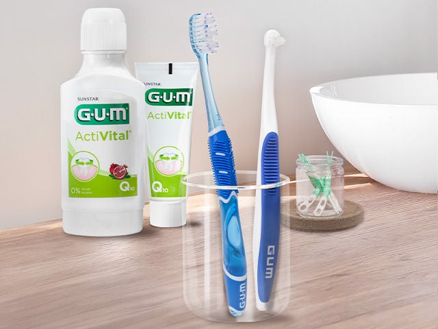GUM END-TUFT and GUM PRO toothbrush in a glass, GUM ActiVital mouthwash and toothpaste, GUM SOFT-PICKS PRO interdental brush, all products in a bathroom